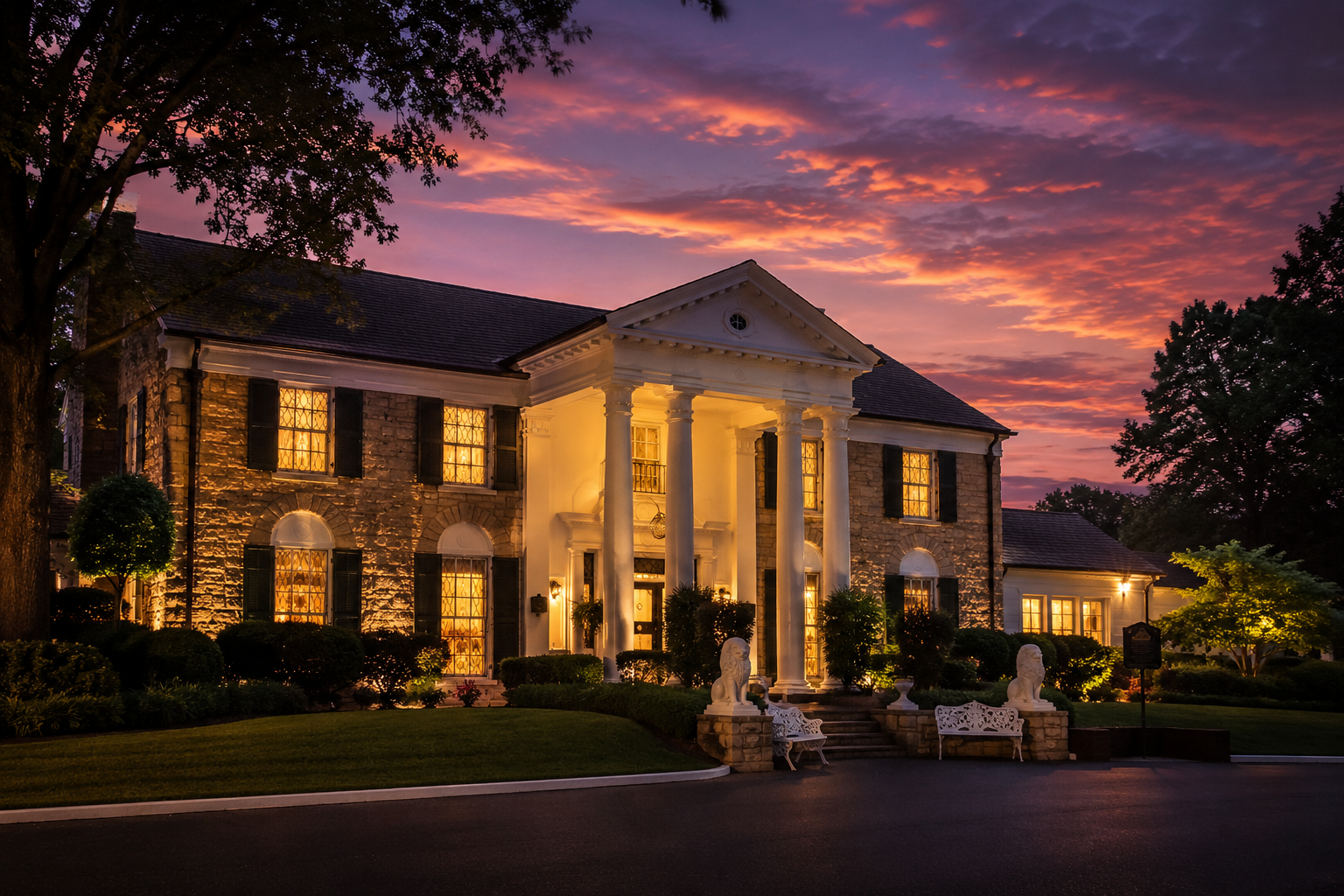 Graceland at early evening with lights in the windows and colorful sunset