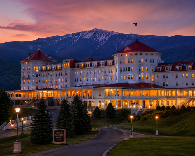 Mount Washington Resort illuminated against the White Mountains at dusk